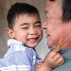 Photo of a father holding his son and smiling. Read about Donor-Advised Funds