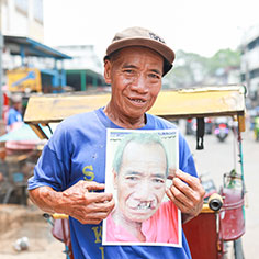 A man holding up a photo. Links to Gifts That Pay You Income