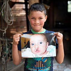 Photo of a boy holding up his photo. Link to Life Stage Gift Planner Over Age 70 Situations.